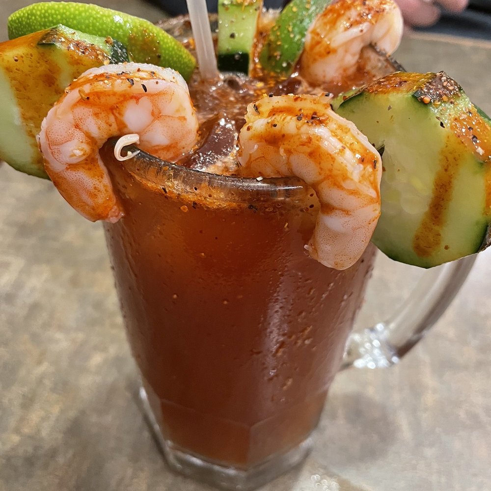Michelada - shrimp and cucumbers with hot sauce and tajin on the rim Michelada - shrimp and cucumbers with hot sauce and tajin on the rim