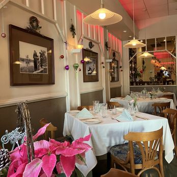 Duc's Bistro - festive interior of Duc's Bistro plus a Christmas plant in the bottom left corner that I put on our table - French Near Me - Honolulu, Hawaii