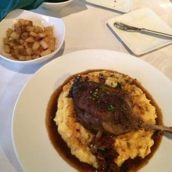 Vestige - Duck confit over grits with a side of potatoes lyonnaise - New American Near Me - Ocean Springs, Mississippi Vestige - Duck confit over grits with a side of potatoes lyonnaise - New American Near Me - Ocean Springs, Mississippi