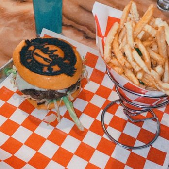Backyard Barbeque - Sunday's Brunch back yard burger w blue Mai ty...great customer service makes you feel like family great music - A burger with a black logo on the bun, served with lettuce and cheese, alongside a basket of French fries and a tall blue cocktail with a lemon wedge. - Barbeque Near Me - Freeport, New York