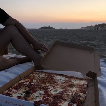 Gino's Long Beach - a person sitting on a blanket with a pizza in a box - Italian Near Me - Long Beach, New York Gino's Long Beach - a person sitting on a blanket with a pizza in a box - Italian Near Me - Long Beach, New York