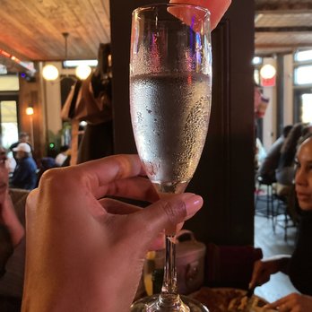 Corner Social - Water served in mimosa glass with a watermelon accessory - New American Near Me - New York, New York