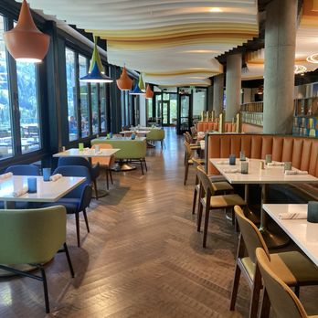 SeventyOne - A restaurant interior featuring large windows, colorful pendant lights, and a mix of seating options including chairs and booths. - American Near Me - Snowbird, Utah