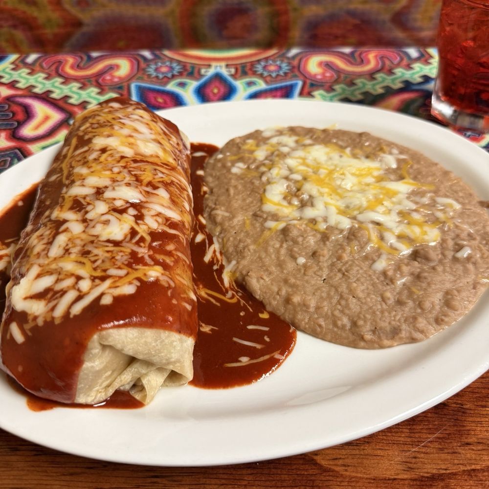 Carne asada burrito enchiladas style and refried beans.