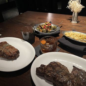 The Vault Steakhouse - New York strip (left), ribeye (right), truffle mac and cheese and the pomegranate brussle sprouts - Steakhouses Near Me - San Francisco, California The Vault Steakhouse - New York strip (left), ribeye (right), truffle mac and cheese and the pomegranate brussle sprouts - Steakhouses Near Me - San Francisco, California