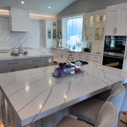 Granite And Marble Direct - Double island kitchen in Calacatta quartz with a full-height slab backsplash. Granite & Marble Direct, New Brighton MN.
