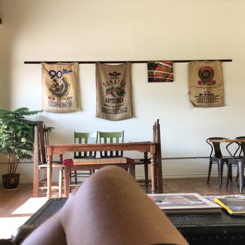 Folklore Coffee - a person's legs on a coffee table - Coffee & Tea Near Me - Conrad, Montana