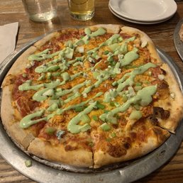 a pizza with green sauce