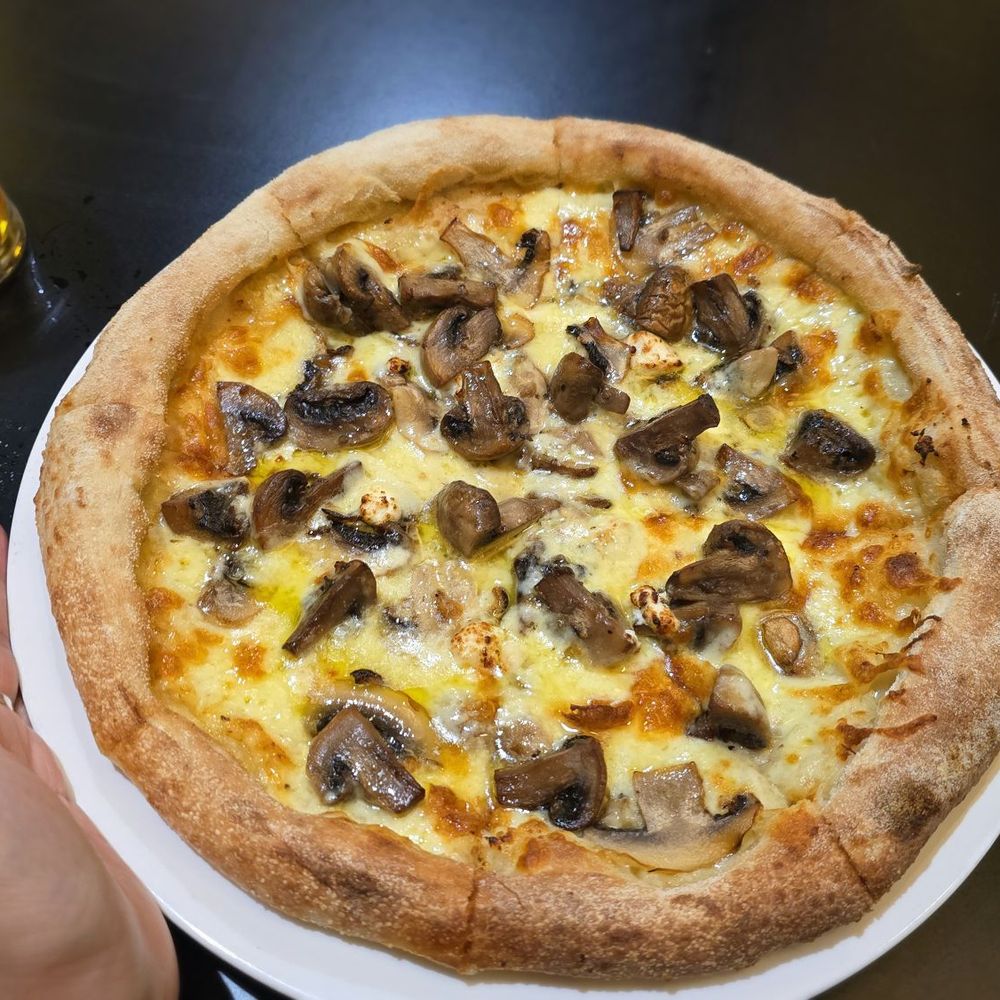 Iluka Tavern - Pizza next to hand to show size. My hand is not that small. Fyi. - Wine Bars Near Me - Coles Bay, TAS