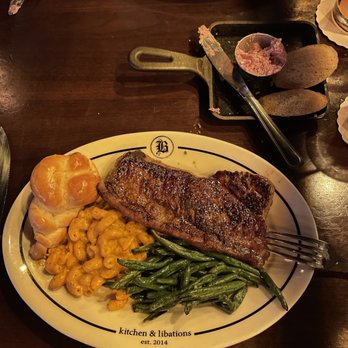Bosscat Kitchen & Libations - Steak night: NY strip, green beans, spicy Mac, roll - New American Near Me - Houston, Texas Bosscat Kitchen & Libations - Steak night: NY strip, green beans, spicy Mac, roll - New American Near Me - Houston, Texas