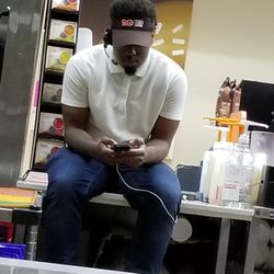 Dunkin' - This is why the customer service is horrible. He's sitting on the co7nter where customers are served inst3ad of taking our order.