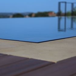 Enduring Pools and Outdoors - Mirrored water effect infinity edge stainless steel pool