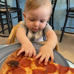 Coast Pizza - Owners son enjoying a slice.