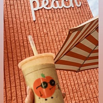 Whata Peach - a hand holding a cup with a straw - Juice Bars & Smoothies Near Me - Studio City, California Whata Peach - a hand holding a cup with a straw - Juice Bars & Smoothies Near Me - Studio City, California