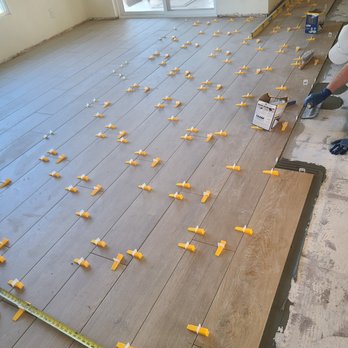 Champion Remodel - a man working on a wood floor - General Contractors Near Me Champion Remodel - a man working on a wood floor - General Contractors Near Me