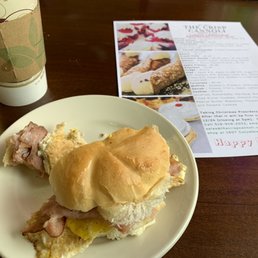 My partially eaten ham and egg sandwich. It's photographed with a mocha latte and the holiday pastry list.