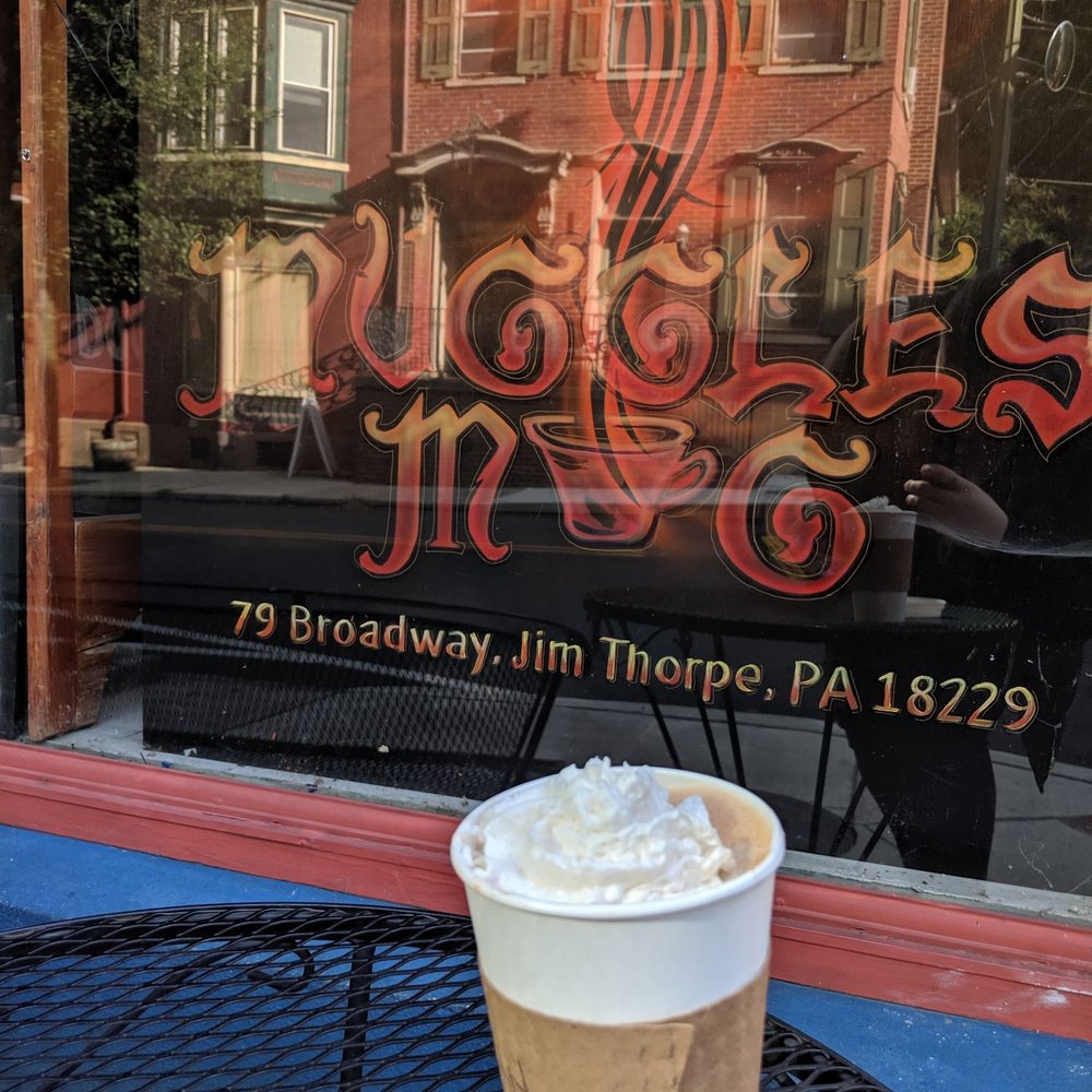 Muggles Mug - Hemp mylk Deathly Hallows hot latte (chocolate and orange) and almond whipped cream on their outside table, in front of their banner. - Coffee & Tea Near Me - Jim Thorpe, Pennsylvania Muggles Mug - Hemp mylk Deathly Hallows hot latte (chocolate and orange) and almond whipped cream on their outside table, in front of their banner. - Coffee & Tea Near Me - Jim Thorpe, Pennsylvania
