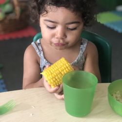 Little Sprouts Language Immersion Preschool - Eating a delicious organic corn