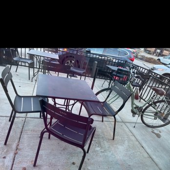 Starbucks - An outdoor patio features several tables and chairs, with bicycles parked nearby, and a parking lot with cars in the background. - Coffee & Tea Near Me - Brookfield, Wisconsin