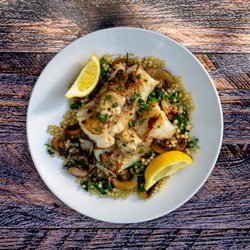 Flying Star Café - Fish Dish - Seasoned, pan fried Wild Alaskan Cod, with porcini butter, over sautéed fresh spinach, mushrooms, & Israeli couscous.