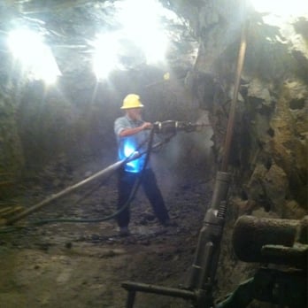 Sierra Silver Mine Tour - Mine guide demonstrating mining equipment. - Tours Near Me - Wallace, Idaho