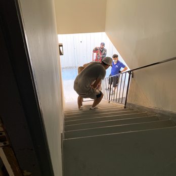 A2 Moving - Long Beach - Mover with dolly not wearing a mask. One mover safely taking items down the stairs - Movers Near Me - Long Beach, California