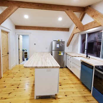 Shapiro Bathrooms - a kitchen with wood flooring and white cabinets - General Contractors Near Me - Hooksett, New Hampshire