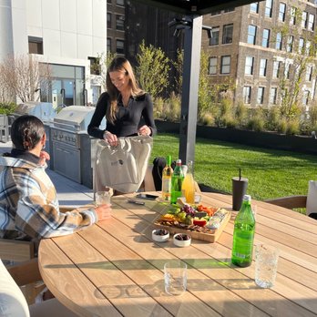 Montague Wine & Spirits - a woman serving a meal on a patio table - Beer, Wine & Spirits Near Me - Brooklyn, New York Montague Wine & Spirits - a woman serving a meal on a patio table - Beer, Wine & Spirits Near Me - Brooklyn, New York