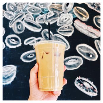Kettle Glazed Doughnuts - a hand holding a cup of iced coffee - Donuts Near Me - Hollywood, California