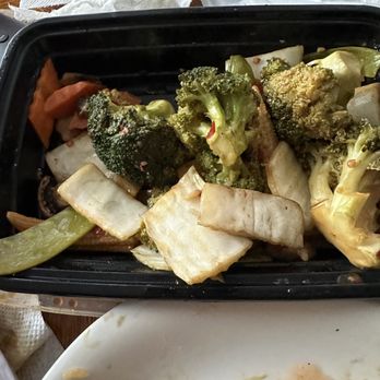Siu's Asian Bistro - Hunan veggies - A black takeout container holds steamed broccoli, cauliflower, and mixed vegetables, with some remnants of food on a nearby plate. - Chinese Near Me - Silver Spring, Maryland
