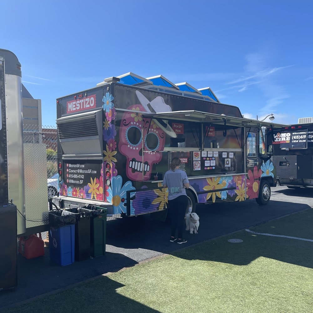 a food truck parked in a parking lot a food truck parked in a parking lot
