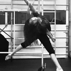 Gravity Aerial Arts - Suspended in air by 2 flat straps wrapped around the wrists, Faith sustains herself in the butterfly pose.