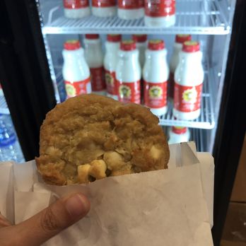 Insomnia Cookies - White Chocolate Macadamia with bottles of milk pictured behind - Desserts Near Me - Jacksonville, Florida Insomnia Cookies - White Chocolate Macadamia with bottles of milk pictured behind - Desserts Near Me - Jacksonville, Florida