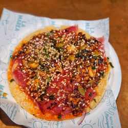 Aged tuna tostada with peanut salsa matcha, furikake and shio koji