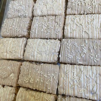 Indulgence - a tray of cookies with white icing - Chocolatiers & Shops Near Me