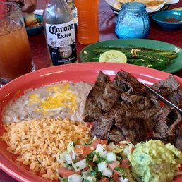 Carne asada accompanied by a Corona Michelada Carne asada accompanied by a Corona Michelada