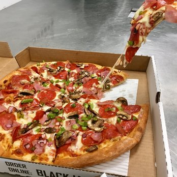 Blackjack Pizza - a hand holding a slice of pizza - Pizza Near Me - Pueblo, Colorado Blackjack Pizza - a hand holding a slice of pizza - Pizza Near Me - Pueblo, Colorado