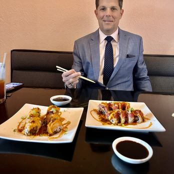Umii Grill - a man sitting at a table with plates of food - Japanese Near Me - Terre Haute, Indiana Umii Grill - a man sitting at a table with plates of food - Japanese Near Me - Terre Haute, Indiana