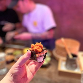 Sushi On Me - a person holding a piece of sushi - Japanese Near Me - Jackson Heights, New York Sushi On Me - a person holding a piece of sushi - Japanese Near Me - Jackson Heights, New York