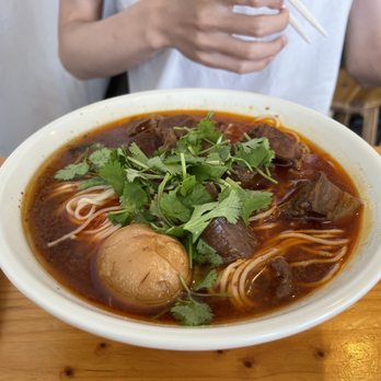 Show Mian - a person holding chopsticks and a bowl of soup - Chinese Near Me - Plano, Texas