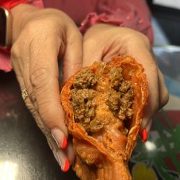 a woman's hands holding a piece of food