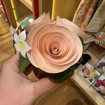 Renwick Gallery - A handcrafted paper flower resembling a rose, accompanied by a paper butterfly, held in a person's hand. - Art Galleries Near Me - Washington, DC, District of Columbia