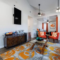 The Brook on Bay Area - Vibrant and welcoming lounge featuring bold orange accents, plush seating, and modern décor...