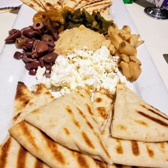 Reginelli's Pizzeria - Dressed Hummus: White Bean and Chickpea Hummus with roasted pepper blend, kalamata olives, feta, roasted garlic served with pita. - Pizza Near Me - Metairie, Louisiana Reginelli's Pizzeria - Dressed Hummus: White Bean and Chickpea Hummus with roasted pepper blend, kalamata olives, feta, roasted garlic served with pita. - Pizza Near Me - Metairie, Louisiana