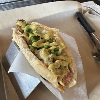 Bangers & Brews - Westside - Smoked Andouille Sausage with spicy mustard, jalapeños, and sauerkraut. (And a bite taken out so you can see the inside.) - German Near Me - Bend, Oregon