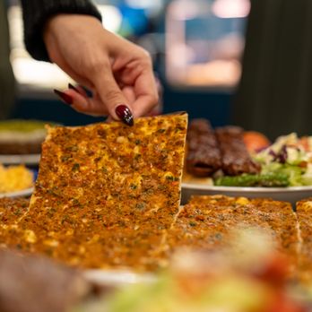 Istanbul Kebab House-Toronto - a person grabbing a piece of pizza - Kebab Near Me - Toronto, Ontario Istanbul Kebab House-Toronto - a person grabbing a piece of pizza - Kebab Near Me - Toronto, Ontario