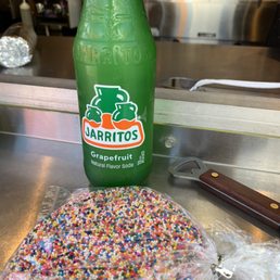 a bottle and sprinkles on a table a bottle and sprinkles on a table