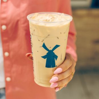 Dutch Bros Coffee - a woman holding a cup of iced coffee - Coffee & Tea Near Me - Redding, California