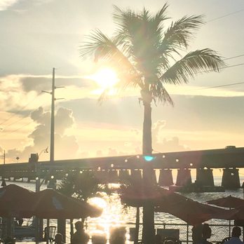 Sunset Grille & Raw Bar - Sunset from the open-air dining overlooking the pool and water - Seafood Near Me - Marathon, Florida Sunset Grille & Raw Bar - Sunset from the open-air dining overlooking the pool and water - Seafood Near Me - Marathon, Florida