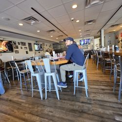Top Dawgs Pub & Deli - Some customers seated at one of the high tables in the middle of the restaurant pub.
